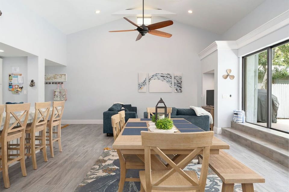 Large Farm Table Dining Area with Full Sliding Glass Doors That Open to Pool 