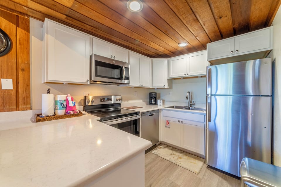 Upgraded kitchen with solid stone countertops and stainless steel appliances.
