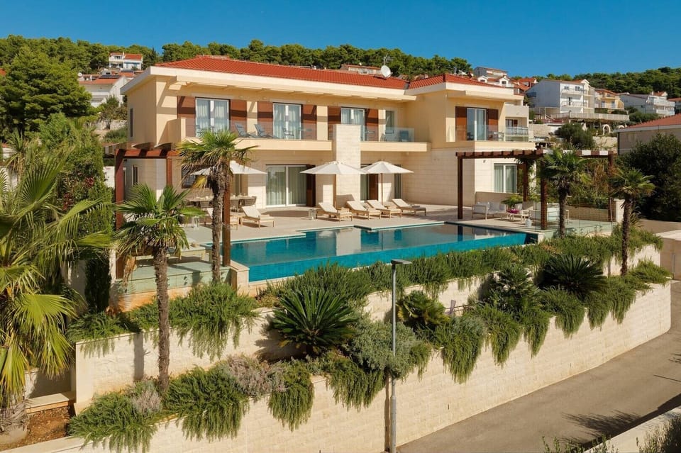 Luxury Croatia sea view villa with private pool surrounded by deckchairs and sundeck for vacation
