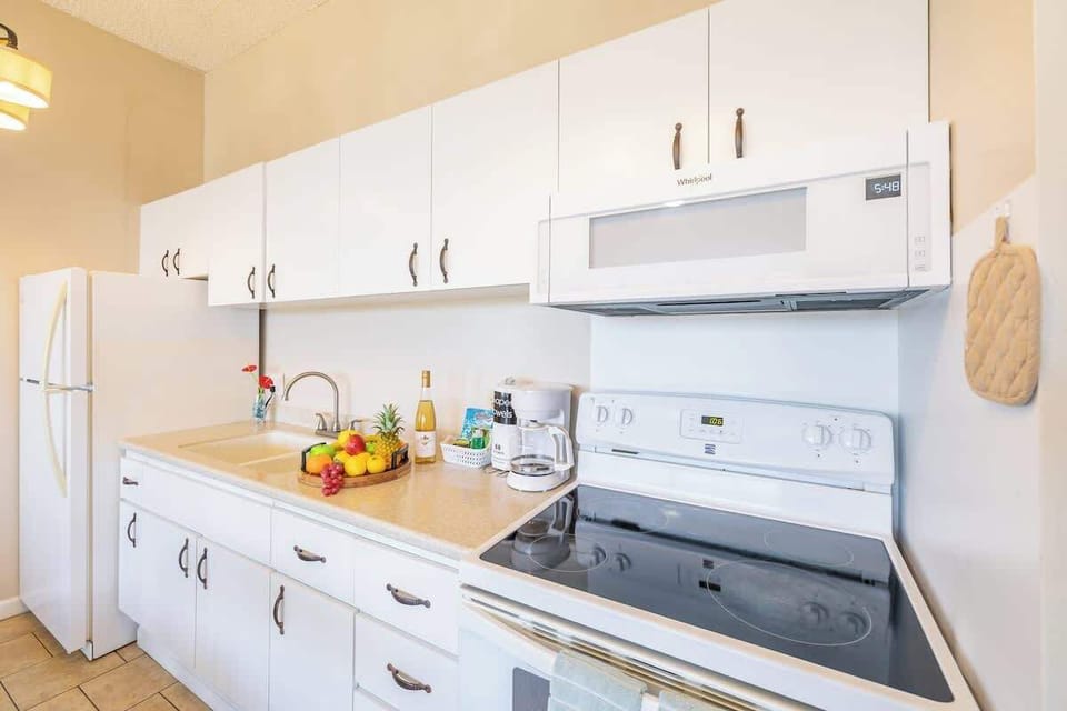 Bright kitchen with white cabinetry and modern appliances for convenient cooking.