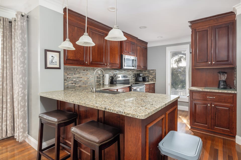 Airy Kitchen with bar seating and granite countertops