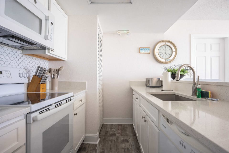 Updated Kitchen with white granite countertops and beautiful tiled backsplash