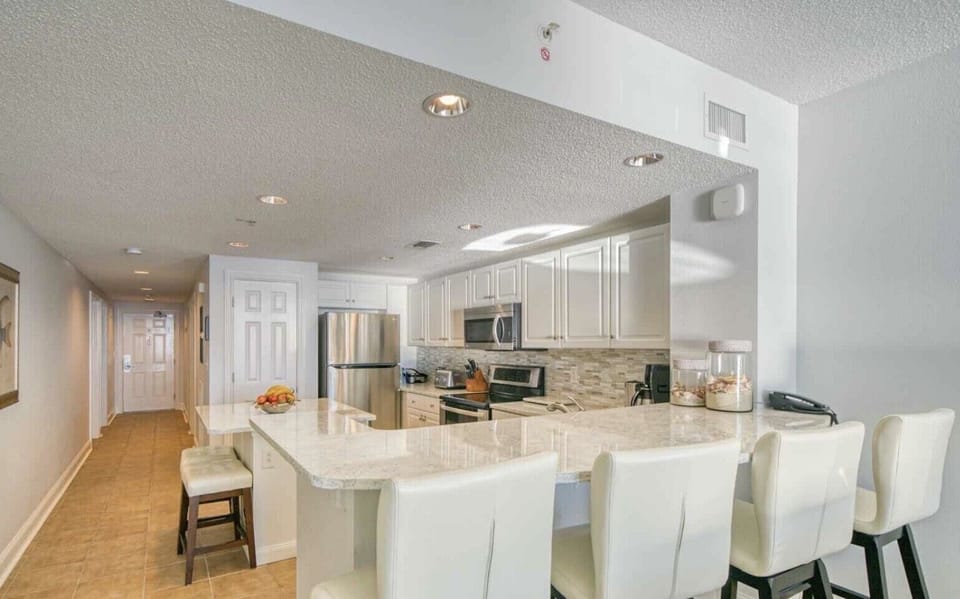 Fully stocked kitchen with quartz counter tops and bar seating 