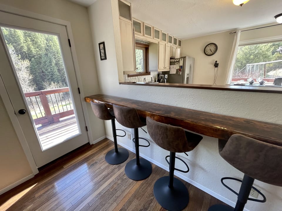 Breakfast bar with full length glass door to deck over looking the lawn.