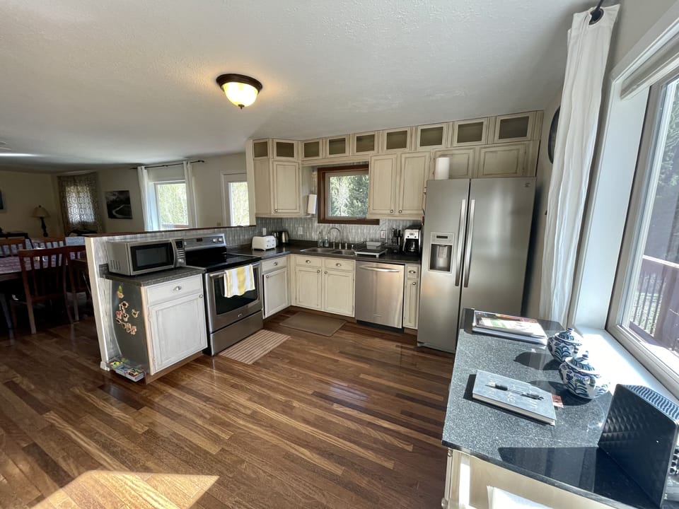 Fully stocked kitchen with many appliances, spices, plate ware and glass ware. 