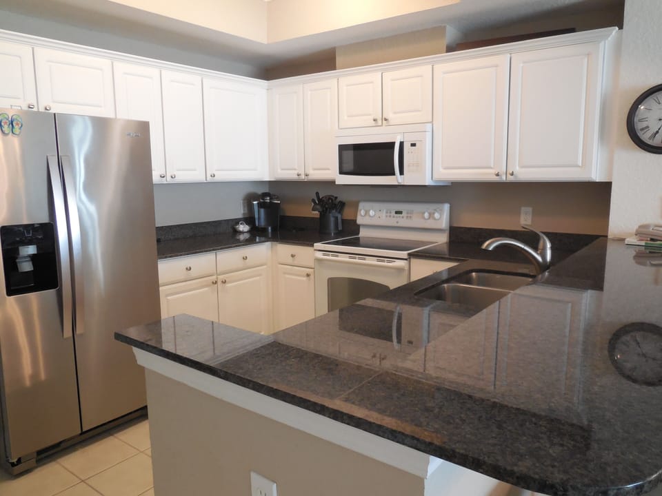 Well equipped kitchen with granite countertops.
