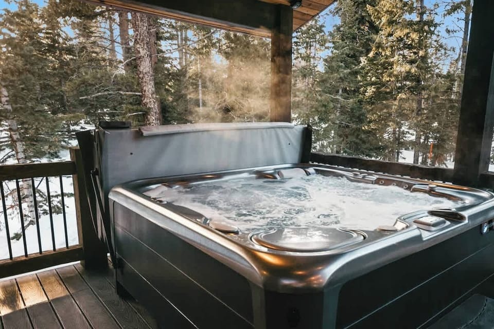 Private outdoor hot tub surrounded by towering pines