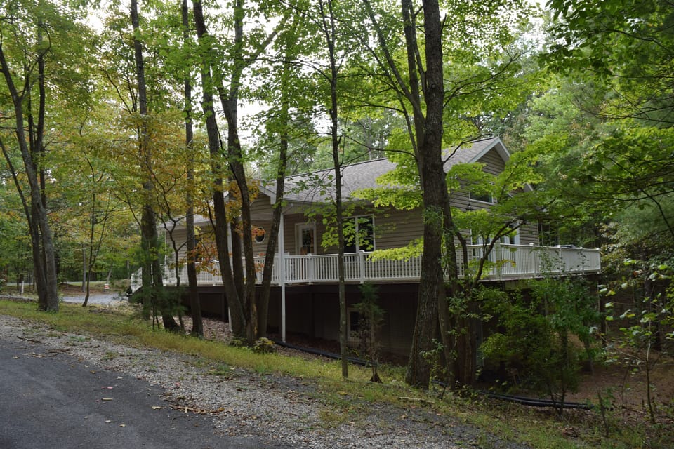 Front and side view house with wrap around deck.