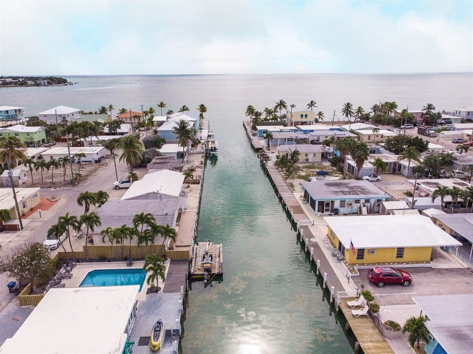 Aerial view showcasing the home's desirable canal-front setting with quick boating access to open water.