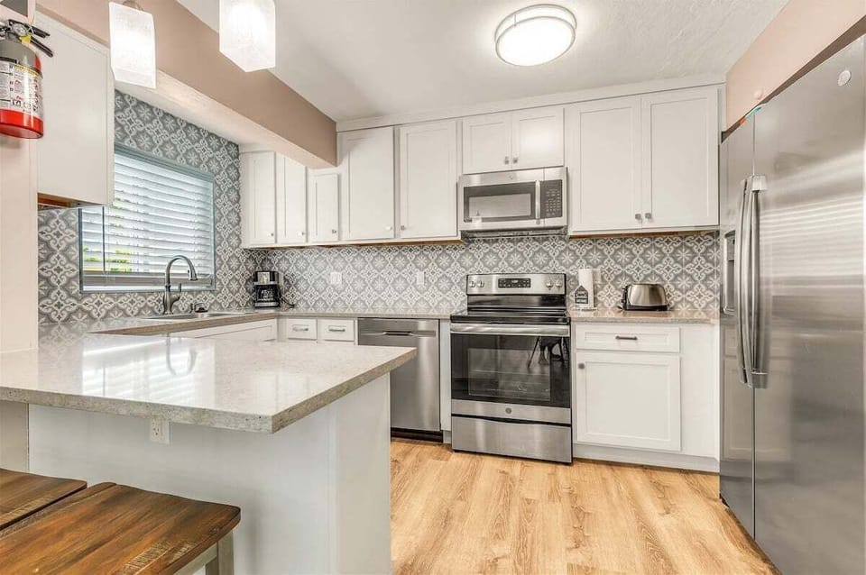 Fully equipped kitchen with stainless steel appliances, ample cabinetry, and generous counter space.