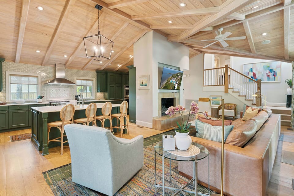 Relax in this stunning open-concept living space featuring soaring wood-beamed ceilings, a cozy fireplace, and a fully equipped kitchen—your perfect home away from home.