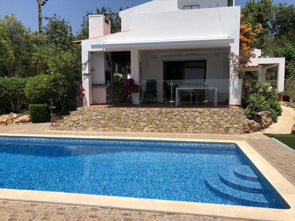 Terrace with glass balustrade, BBQ and pool, with awning shading terrace