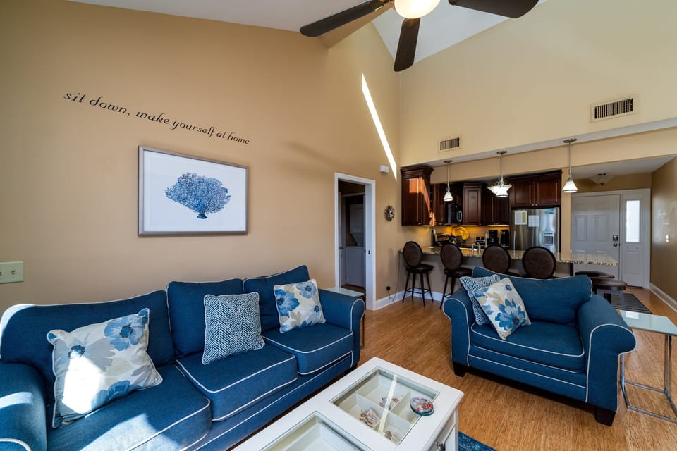The great room has vaulted ceilings, fan, and comfortable furniture