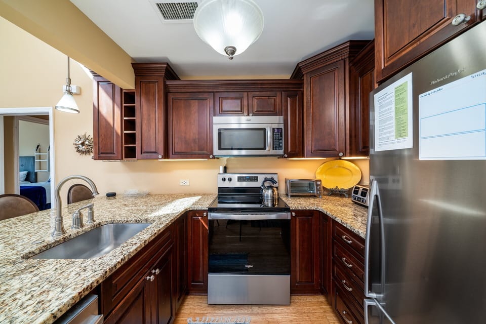 Fully stocked kitchen is updated with granite counter tops,
custom walnut cabinets and stainless appliances.