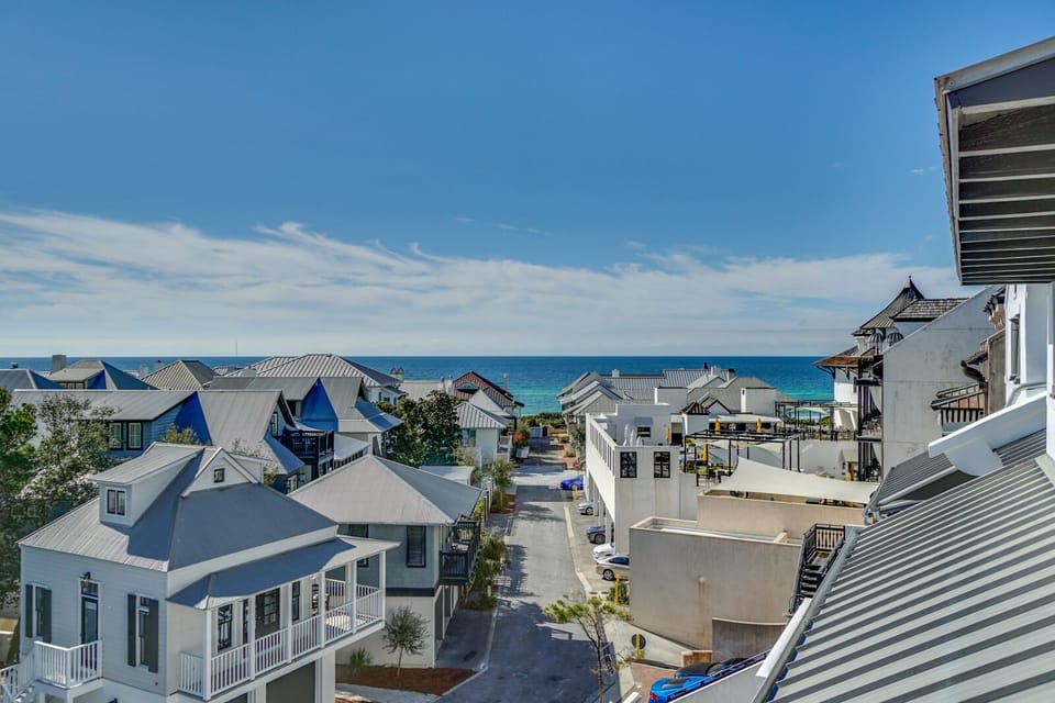 Charming beachside neighborhood with coastal architecture and stunning turquoise waters just steps away from this elevated location.