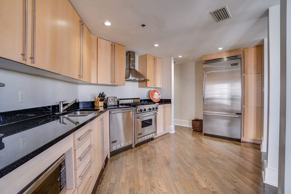 Cook your favorite meals in this sleek kitchen featuring professional-grade stainless steel appliances, granite countertops, and ample cabinet storage for all your culinary adventures.