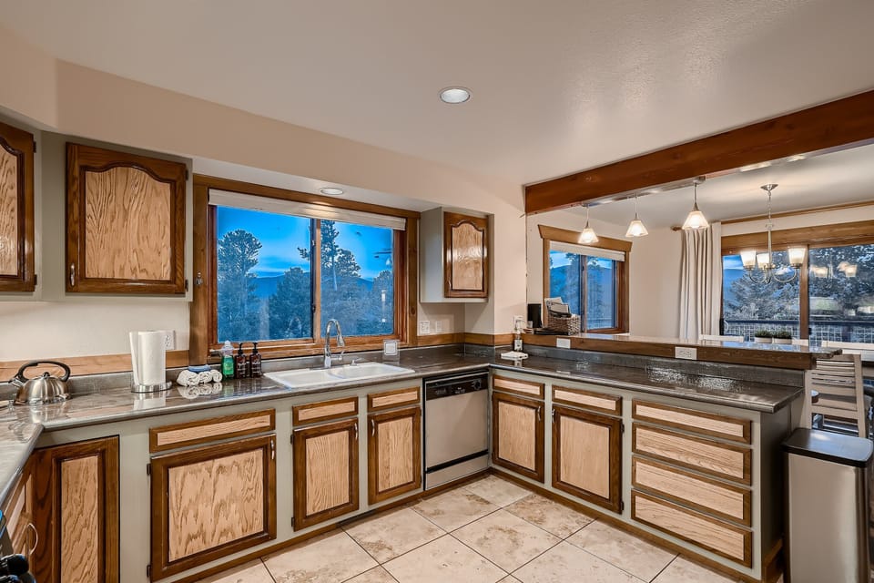 A kitchen with wood cabinets and a view of the mountains.
