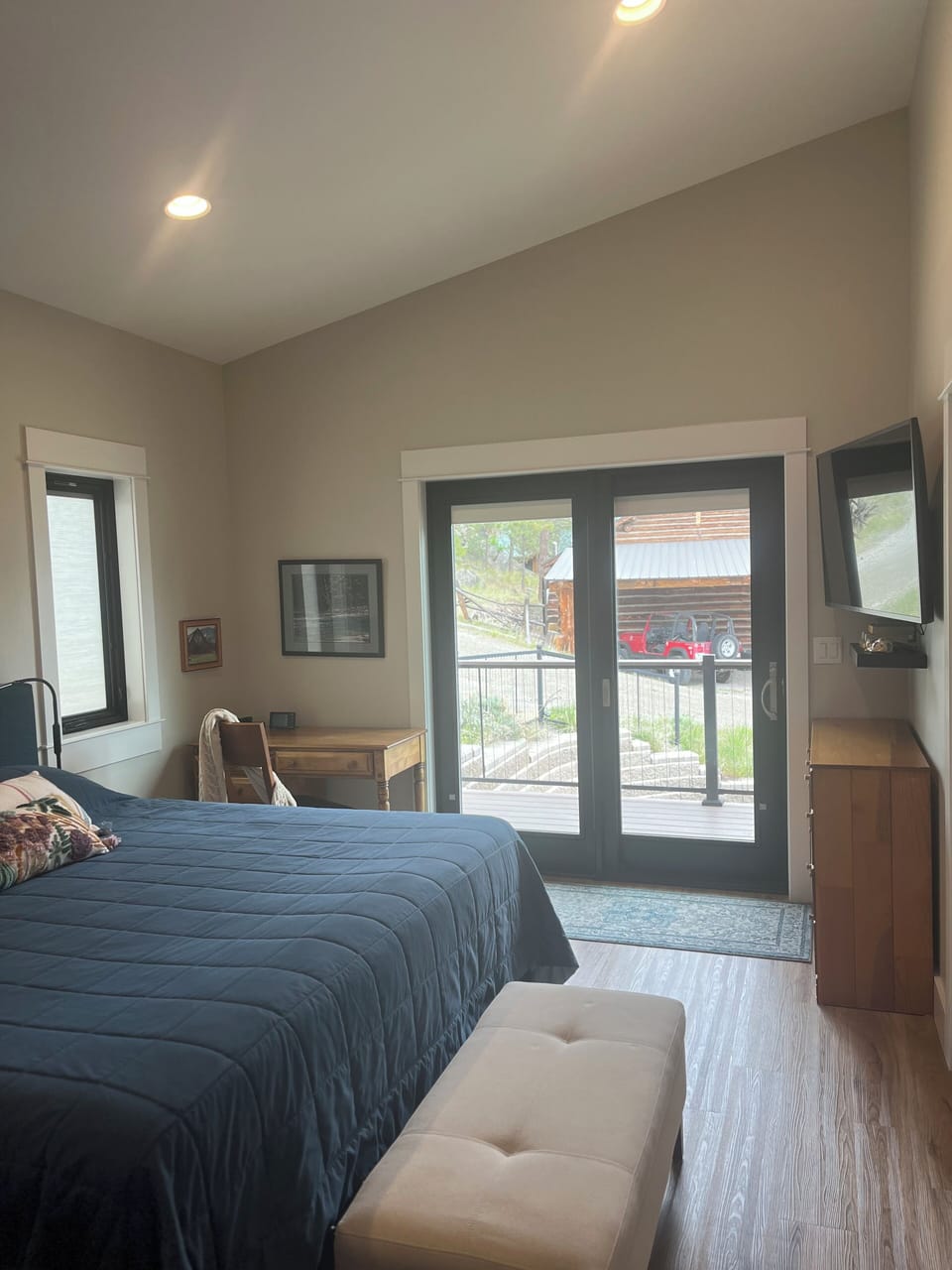 Looking out the sliding door.  Smart TV, desk & dresser.