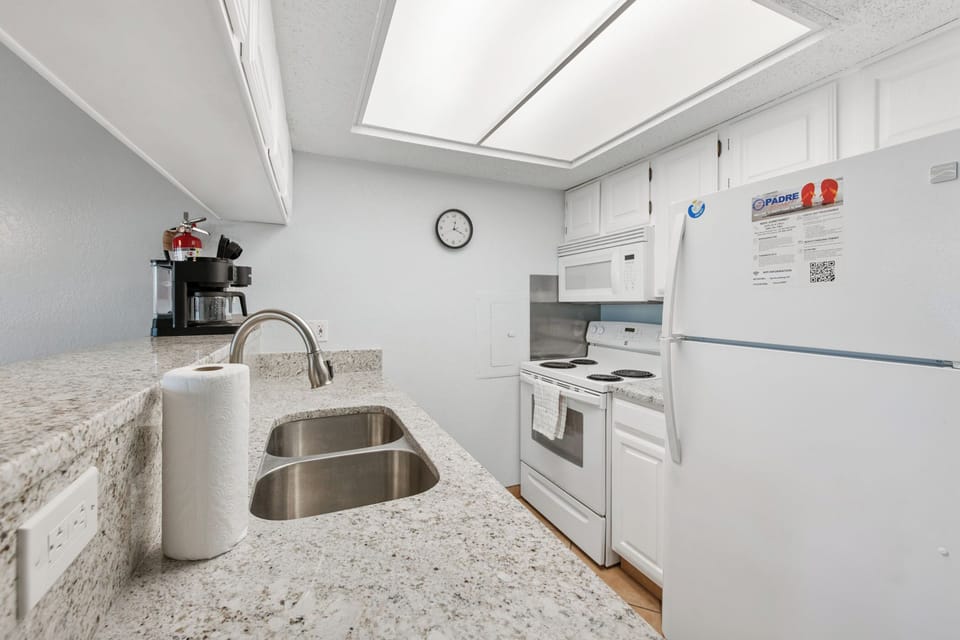 Your fully equipped kitchen features granite counters, white appliances, and everything you need to prepare home-cooked meals during your stay.