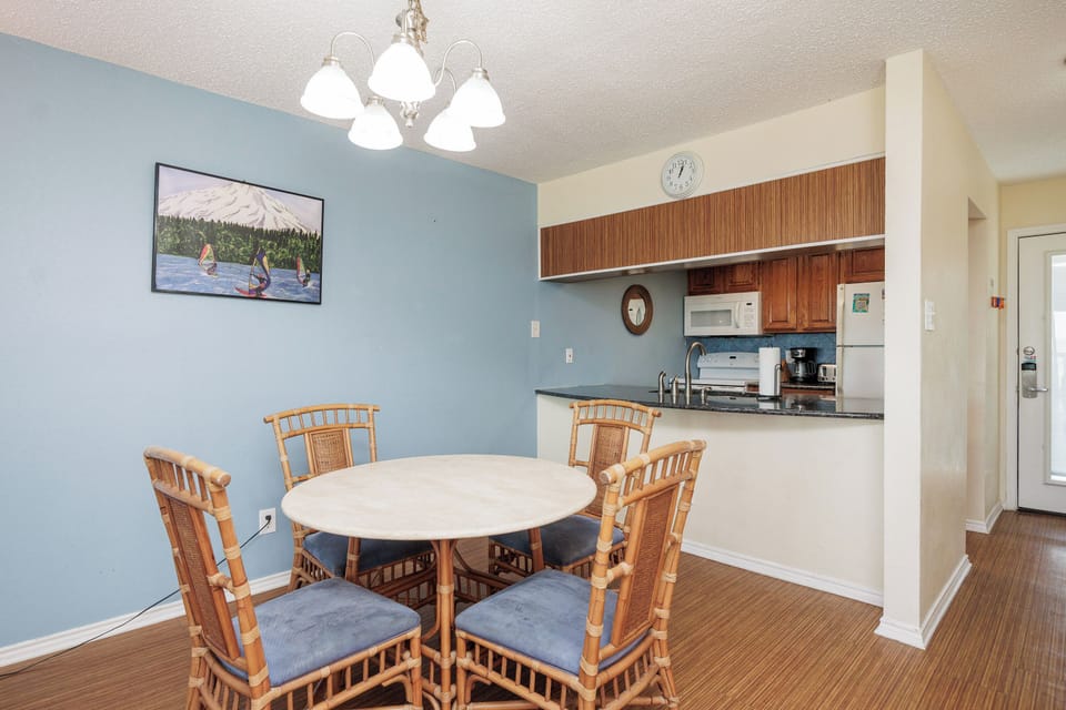 Your open dining area flows seamlessly into the fully equipped kitchen, perfect for preparing meals and gathering around the charming round table.