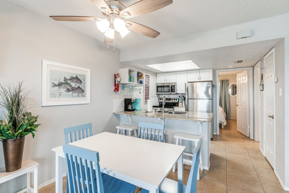 Gather around your bright dining table, where the open kitchen invites easy meal prep and the ceiling fan keeps you cool.