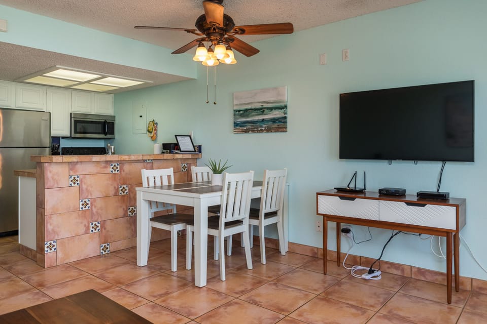 Your open-concept living space combines kitchen, dining, and entertainment in coastal style with modern amenities and soothing sea-themed decor.