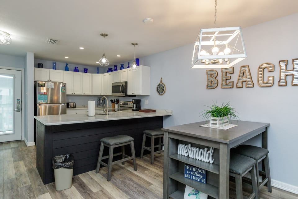 Your fully equipped kitchen features modern appliances and beach-themed charm, perfect for preparing meals while enjoying coastal-inspired décor.