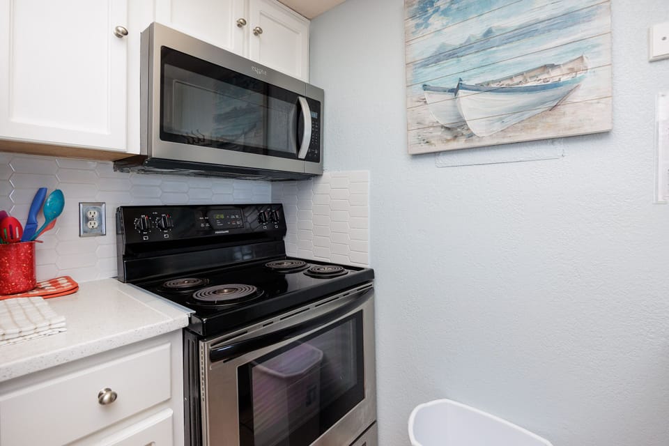 Your fully equipped kitchen features modern appliances and coastal artwork to inspire your culinary adventures.