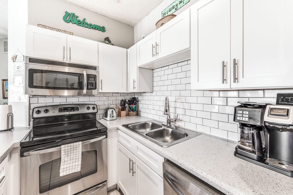 Your fully equipped kitchen features modern appliances, granite countertops, and crisp white cabinetry for effortless meal preparation.
