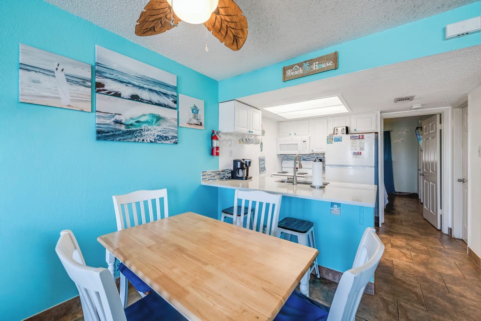 Gather around your beach-themed dining table, where ocean-inspired décor and a fully equipped kitchen await your morning coffee ritual and meal preparations.