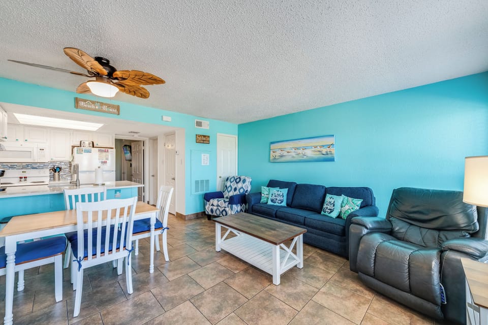 Kick back in this coastal-inspired living room featuring a plush sofa, comfy recliner, and accent chair—the perfect spot to relax after a day at the beach with dune views right outside.