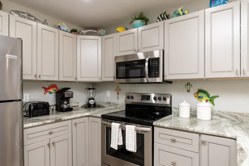Your fully equipped kitchen features granite countertops, stainless steel appliances, and cheerful coastal touches that make cooking feel like a vacation.