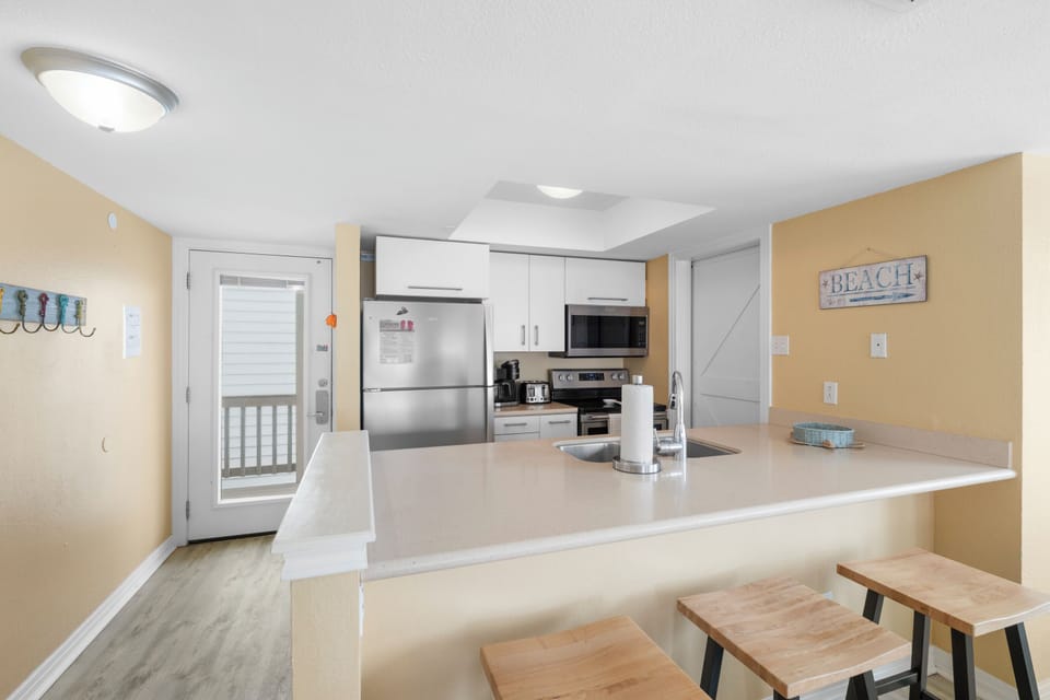 Your bright, fully-equipped kitchen features modern appliances and a breakfast bar where you can start each day with coffee and ocean views.