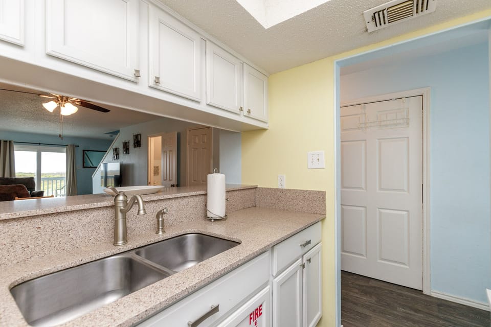 Your bright kitchen features granite counters, double sink, and white cabinets, perfect for preparing meals during your stay.