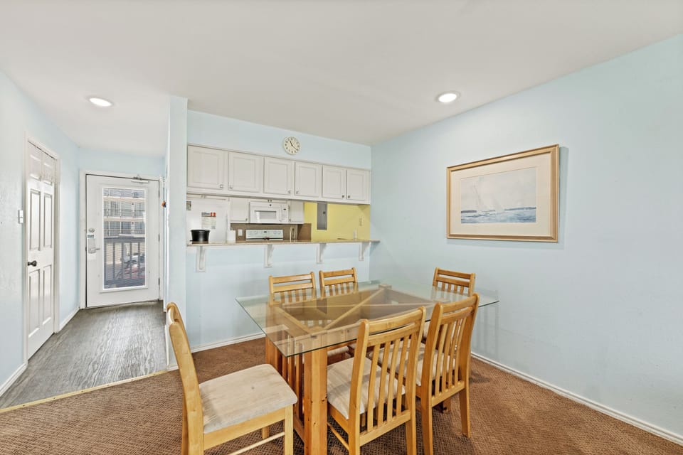 Gather around this inviting dining table where you can share meals and make memories together. The open layout connects seamlessly to your kitchen, making every meal feel effortless and relaxed.