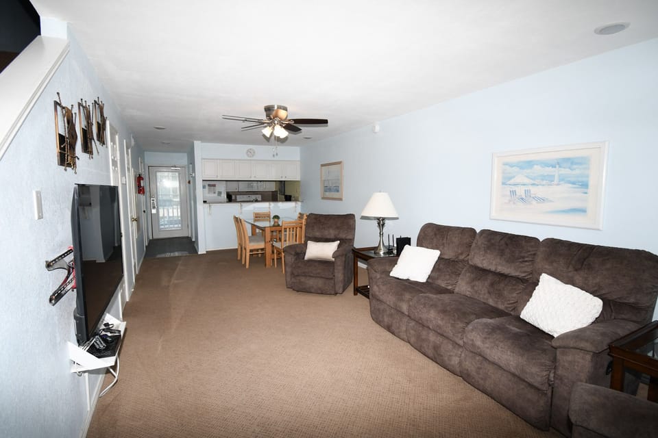 Sink into this plush sectional sofa and unwind in your spacious living area, complete with coastal artwork and an open kitchen.