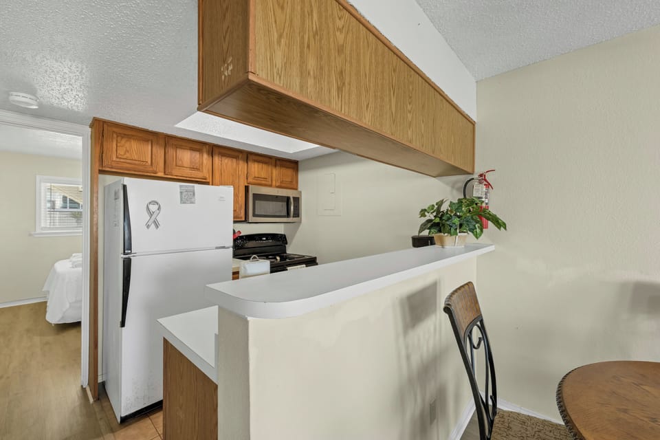 Your fully equipped kitchen features modern appliances and a convenient breakfast bar, perfect for preparing meals during your stay.