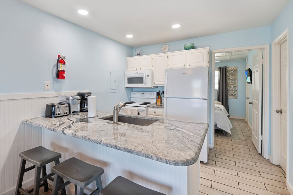 Your fully-equipped kitchen features granite counters, modern appliances, and a breakfast bar perfect for morning coffee and meal prep.