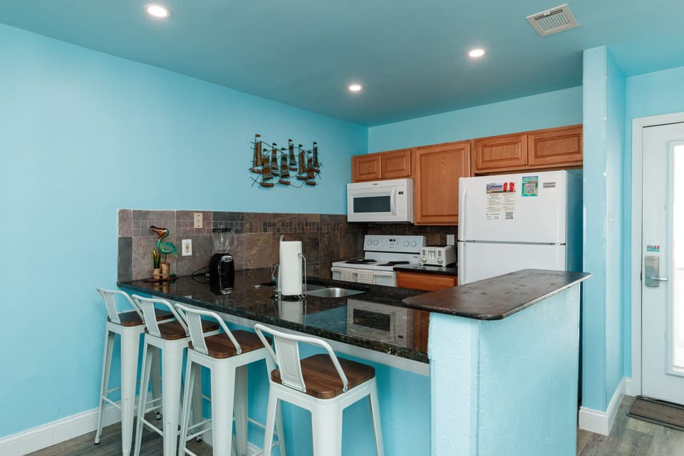 Your coastal-inspired kitchen features modern appliances and breakfast bar seating where you can enjoy morning coffee or quick meals together.