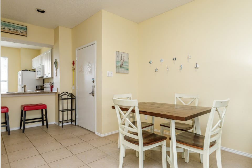 Gather around your charming dining table for morning coffee or evening meals in this bright, coastal-themed space.