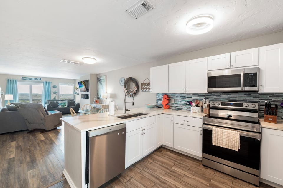 Whip up your favorite meals in this bright, fully-equipped kitchen with granite counters, stainless steel appliances, and ocean-themed touches.