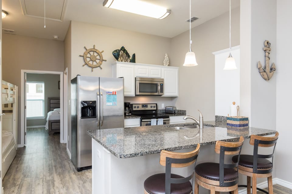 Your fully equipped kitchen awaits with granite counters, stainless appliances, and a breakfast bar perfect for morning coffee together.