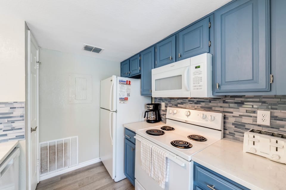 Your fully-equipped kitchen features stylish blue cabinets, modern appliances, and everything you need to prepare delicious meals during your stay.