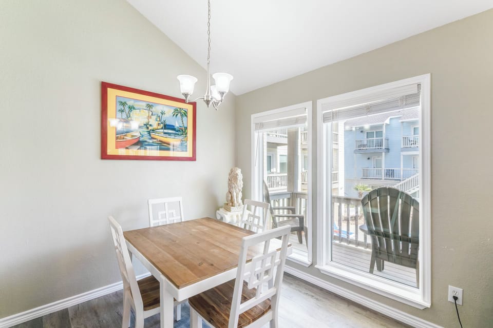 Gather around your dining table for memorable meals, with balcony doors opening to fresh air and charming views of neighboring buildings.
