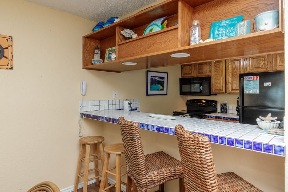Your coastal kitchen awaits with cheerful blue tile accents, wicker seating, and everything you need for memorable vacation meals.