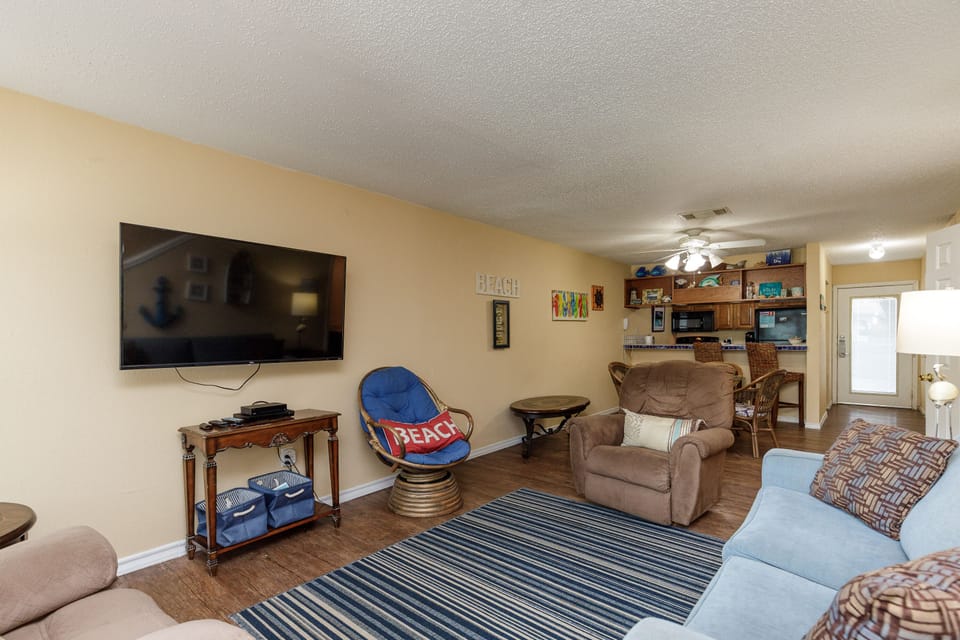 Unwind in your spacious living room with comfy seating, large TV, and coastal décor that sets the perfect beach vacation mood.