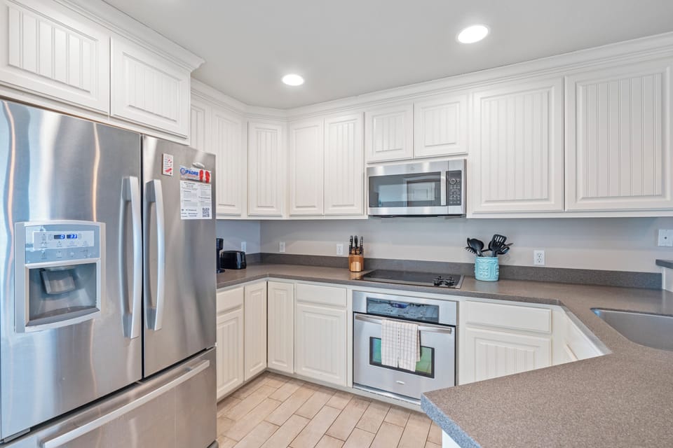 Your fully equipped kitchen awaits with gleaming stainless steel appliances, ample counter space, and everything you need to create memorable meals.