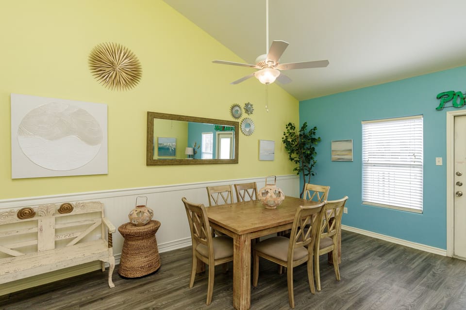 Gather around this bright dining space where cheerful yellow and turquoise walls create a welcoming atmosphere for your family meals and conversations.