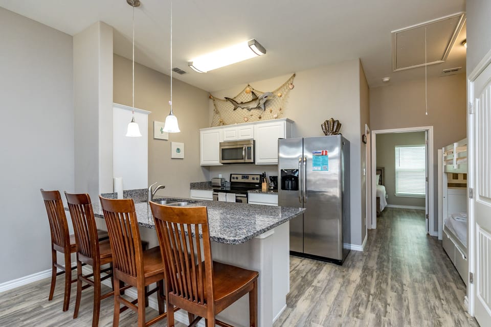 Your bright, modern kitchen invites home-cooked meals with granite counters, stainless appliances, and a cozy breakfast bar perfect for morning coffee.