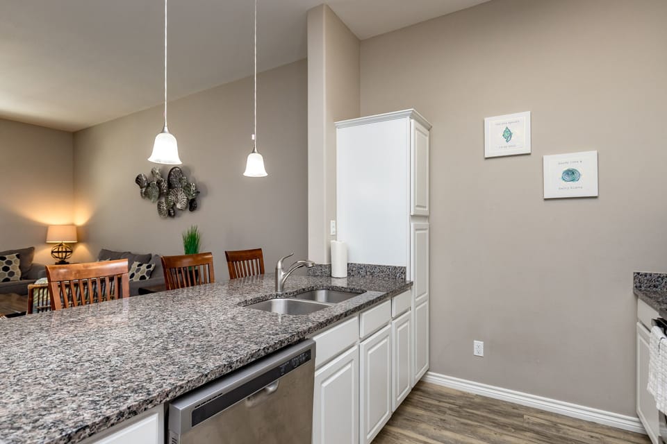 You'll love preparing meals in this modern kitchen with granite counters, white cabinets, and dishwasher, all flowing seamlessly into your dining area.
